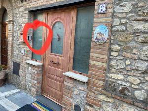 a wooden door with a red heart in front of a building at La Bomboniera di Marco in Fabro
