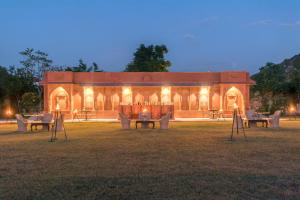 a building with tables and chairs in front of it at Mundota Fort And Palace in Pachār