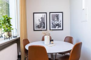 a white dining room with a white table and chairs at Stora Hotellet Markaryd in Markaryd