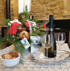 een tafel met een fles wijn en bloemen bij A casa di Mammì nella Valle dei templi in Agrigento