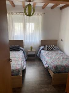 1 dormitorio con 2 camas y ventana en El Descanso Lastres, en Colunga