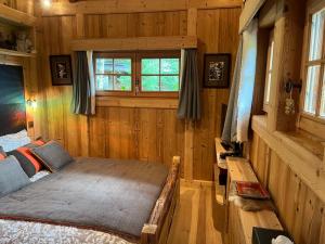 um quarto com uma cama num quarto com paredes de madeira em Chalet Québec em Saint-Nicolas-la-Chapelle