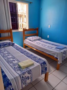 2 Betten in einem Zimmer mit blauen Wänden in der Unterkunft Apartamento Mobiliado Vila Iracema in Fortaleza
