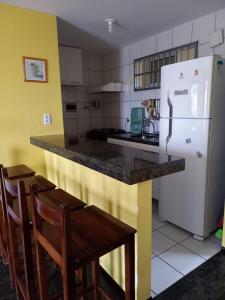 a kitchen with a counter and a white refrigerator at Apartamento Mobiliado Vila Iracema in Fortaleza