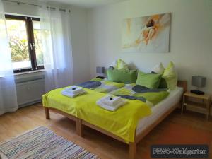 - une chambre avec un grand lit et des serviettes dans l'établissement Ferienwohnung Waldgarten, à Bad Münstereifel