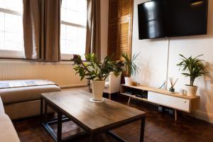 a living room with a table and potted plants at Hampstead 19th Century Village Cottage in London