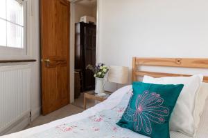 a bedroom with a bed with a green pillow on it at Hampstead 19th Century Village Cottage in London