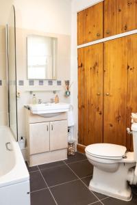 a bathroom with a white toilet and a sink at Hampstead 19th Century Village Cottage in London