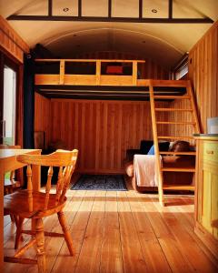 a bedroom with a bunk bed and a table and a chair at Shepherds Hut in a private meadow with sea views in Hartland