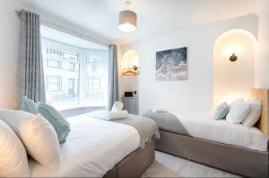 1 dormitorio con 2 camas y ventana en Groves House Swansea City Centre No pets, en Swansea