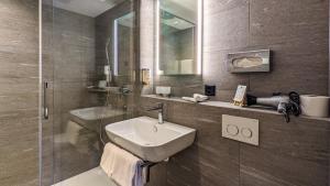 un bagno con lavandino e doccia di Hotel Strandhotel a Iseltwald
