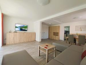 ein Wohnzimmer mit einem Sofa und einem Tisch in der Unterkunft Ferienwohnungen MAXIMA in Bad Arolsen
