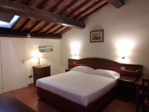 a bedroom with a large white bed with two lights at Relais La Corte di Cloris in Florence