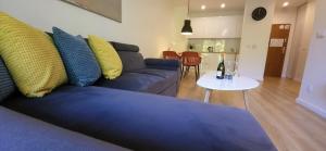 een woonkamer met een blauwe bank en een tafel bij Dwie Sosny Apartamenty Ostrowski in Ustronie Morskie