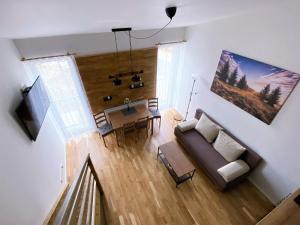 salon z kanapą i stołem w obiekcie Miky Apartmán Klínovec view w mieście Loučná pod Klínovcem