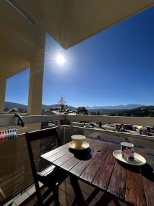 - une table en bois sur un balcon avec une tasse de café dans l'établissement Studio au pied des pistes avec vue • wifi • balcon ..., aux Angles