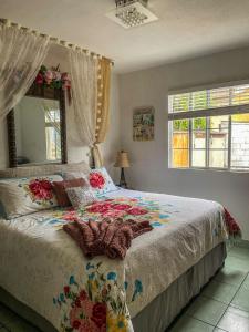 Schlafzimmer mit einem Bett, einem Spiegel und Fenstern in der Unterkunft Cozy Apartment Villas in Rosarito