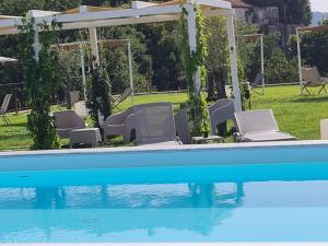 a swimming pool with chairs and a gazebo at HOTEL MYRTUS in Agropoli