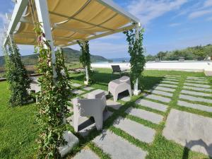 cenador con mesa y sillas en un patio en HOTEL MYRTUS, en Agropoli