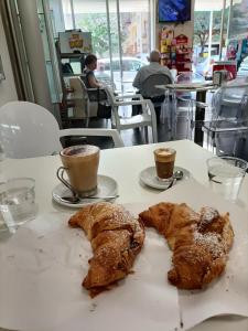 two croissants and two cups of coffee on a table at B&B Carpe Diem in Caserta