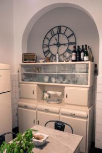 a kitchen with a shelf with a clock on the wall at IN CANNETO...Genova nel cuore. in Genoa