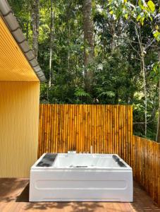 a white bath tub sitting on a deck next to a fence at Kireina Genting Villa in Genting Highlands