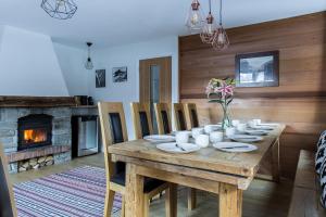 uma sala de jantar com uma mesa de madeira e uma lareira em Chalet Chintalaya em Chamonix-Mont-Blanc
