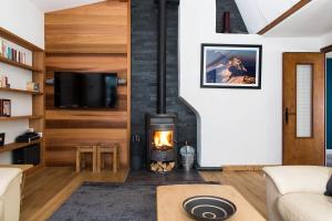 a living room with a fireplace and a tv at Chalet Chintalaya in Chamonix-Mont-Blanc