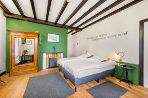 um quarto com uma cama e uma parede verde em Hotel Kasteelhof 'T Hooghe em Ypres