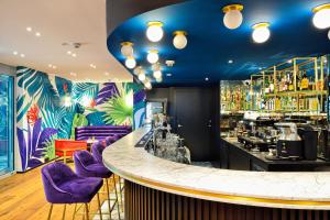bar z fioletowymi krzesłami i kolorową ścianą w obiekcie Hotel Ferreus Modern Art Deco w Krakowie