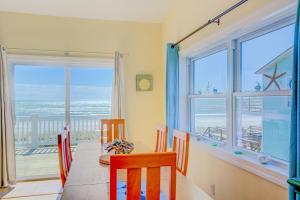 - une salle à manger avec une table et des chaises offrant une vue sur l'océan dans l'établissement Whale Tales, à Surf City