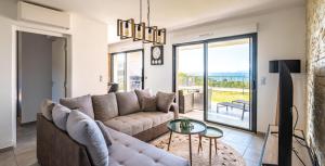 uma sala de estar com um sofá e uma mesa em Les Rivages de Stagnola Appartement T3 vue mer et montagne plage 200m climatisé em Pietrosella