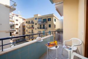 einen Balkon mit einem Tisch, Stühlen und Gebäuden in der Unterkunft Room in BB - BB Sorrento Love You room Capri in Sorrent