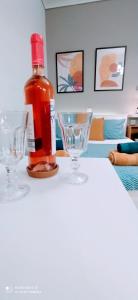 Una botella de alcohol sentada en una mesa con dos vasos. en Elegant Central Studio Free wifi and netflix en Volos
