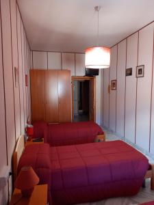 ein Schlafzimmer mit einem roten Bett und einem Sofa in der Unterkunft Affittacamere Su Padru in Ittiri