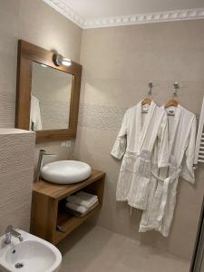 a bathroom with a sink and a toilet and a mirror at Iasskii Torg - La belle epoque in Iaşi