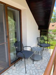 3 Stühle und ein Tisch auf einer Terrasse in der Unterkunft Iasskii Torg - La belle epoque in Iaşi