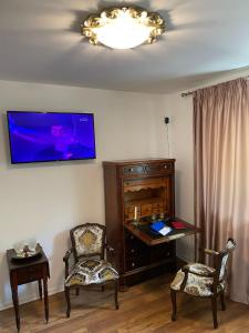 a room with two chairs and a desk and a tv at Iasskii Torg - La belle epoque in Iaşi