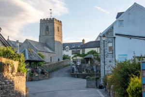 a street in a village with a clock tower at Charming coastal cottage with stunning views - Hope Cottage in Mortehoe