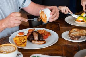 a man drinking coffee with a plate of breakfast food at The Bear in Bath