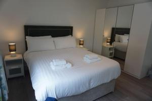 ein Schlafzimmer mit einem großen weißen Bett mit Handtüchern darauf in der Unterkunft Bluestack View Apartment in Donegal