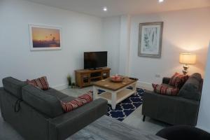 a living room with two couches and a television at Bluestack View Apartment in Donegal