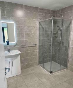 ein Bad mit einer Dusche und einem Waschbecken in der Unterkunft Bluestack View Apartment in Donegal