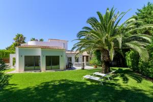 エル・トロにある2705 - Schicke Villa in Santa Ponsa Novaの庭の椰子とベンチのある家