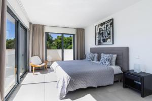 Biała sypialnia z łóżkiem i balkonem w obiekcie 2705 - Schicke Villa in Santa Ponsa Nova w mieście El Toro +37 zdjęć