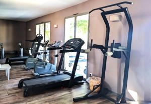 a gym with several tread machines in a room at ALLURA GOLF APPARTEMENT in Saumane-de-Vaucluse