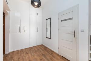 a white room with a door and a mirror at Al. Wyzwolenia 14a by Homeprime in Warsaw