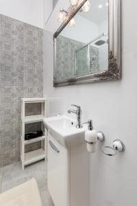 a white bathroom with a sink and a mirror at Al. Wyzwolenia 14a by Homeprime in Warsaw
