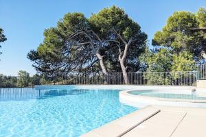 a swimming pool with a fence and trees at Appartement Terrasse avec Vue exceptionnelle Golf in Saumane-de-Vaucluse