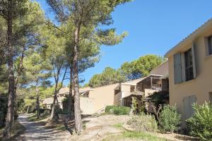 a house with trees in front of it at ALLURA GOLF APPARTEMENT in Saumane-de-Vaucluse
